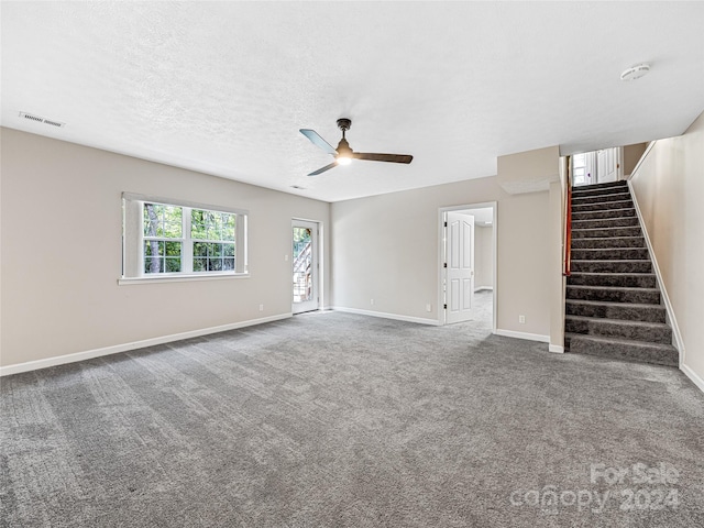 unfurnished living room with ceiling fan, carpet, and a textured ceiling