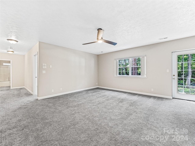 unfurnished room featuring a textured ceiling, carpet flooring, and ceiling fan