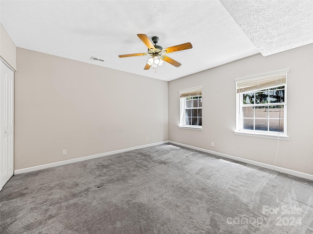 interior space featuring a closet, ceiling fan, carpet flooring, and a textured ceiling