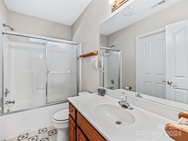 full bathroom featuring combined bath / shower with glass door, vanity, and toilet