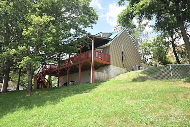 back of property featuring a lawn and a wooden deck