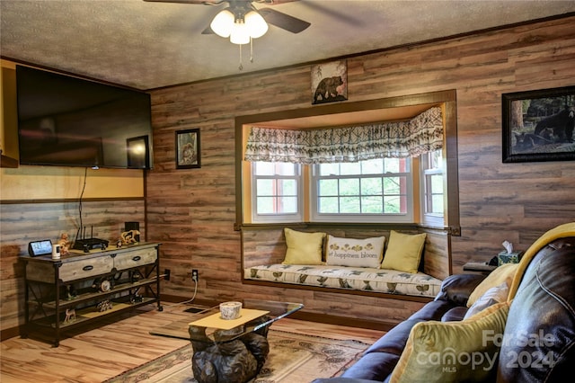 living room with hardwood / wood-style floors, a textured ceiling, and ceiling fan