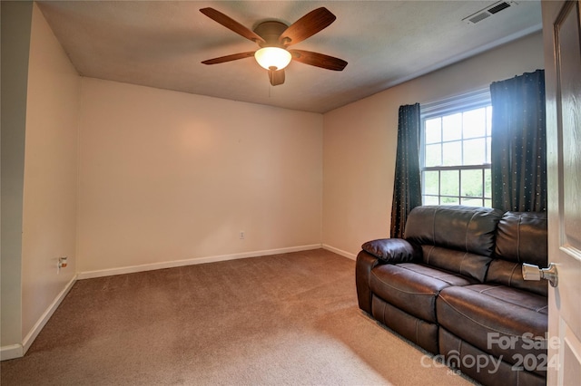 carpeted living room featuring ceiling fan