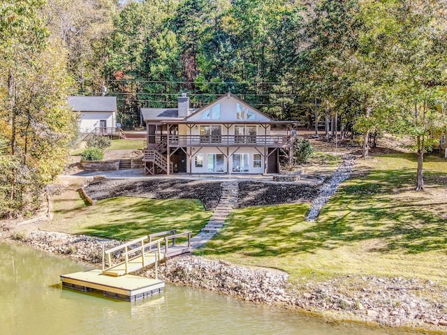 exterior space with a patio area, a yard, and a deck with water view