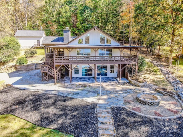 view of front facade with a deck, a patio, and an outdoor fire pit