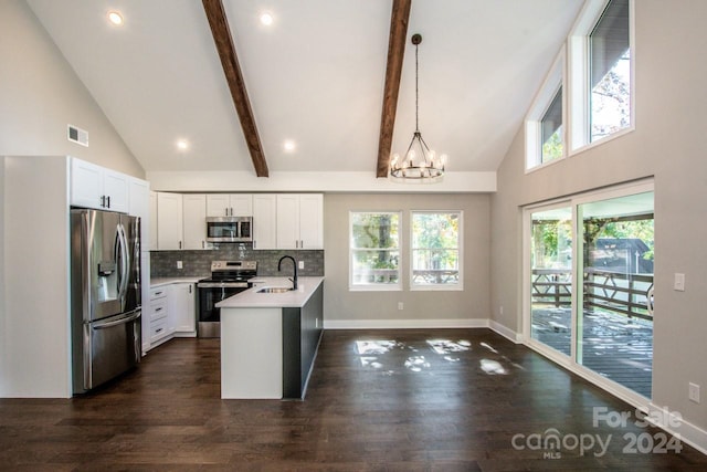 kitchen featuring an island with sink, high vaulted ceiling, decorative light fixtures, and appliances with stainless steel finishes