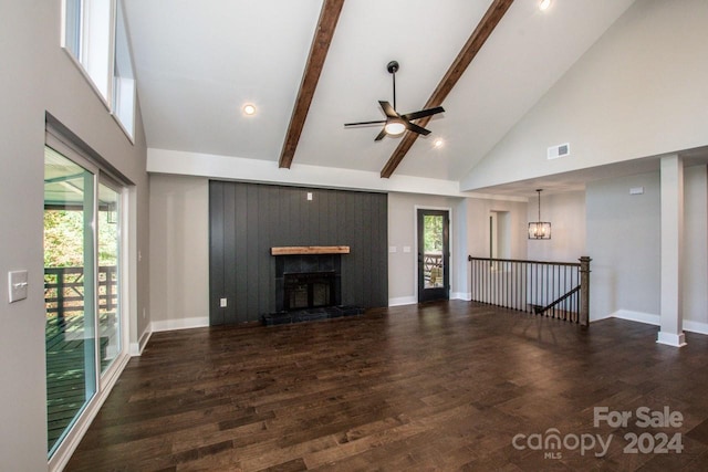 unfurnished living room with dark hardwood / wood-style floors, a healthy amount of sunlight, beam ceiling, and high vaulted ceiling