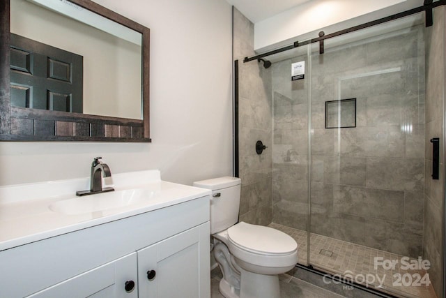 bathroom with vanity, toilet, and a shower with shower door