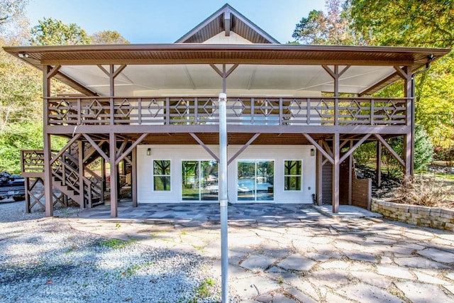 back of property featuring a patio and a wooden deck