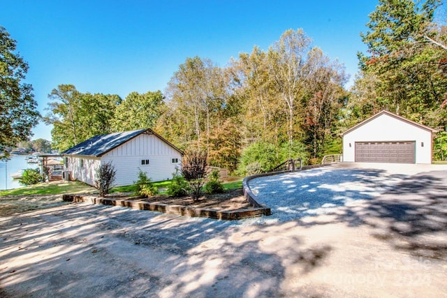 view of side of home featuring a garage and an outbuilding