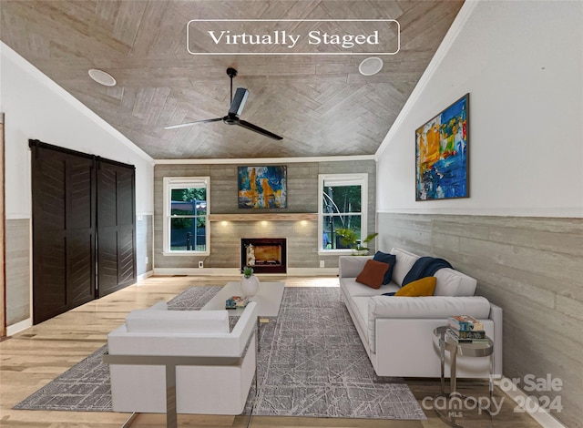 living room with wooden walls, vaulted ceiling, ceiling fan, and ornamental molding