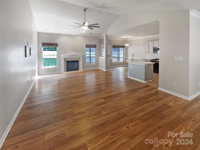 unfurnished living room with ornamental molding, dark hardwood / wood-style flooring, ceiling fan, and lofted ceiling