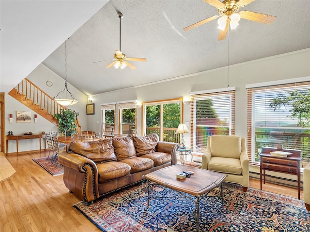 living room with a textured ceiling, light wood-type flooring, ceiling fan, and lofted ceiling