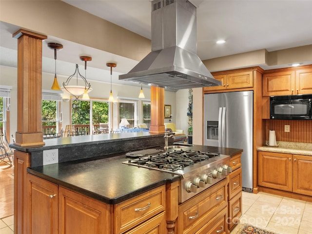 kitchen with pendant lighting, island exhaust hood, light tile patterned floors, stainless steel appliances, and decorative columns