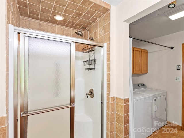 bathroom featuring washer and clothes dryer and a shower with shower door