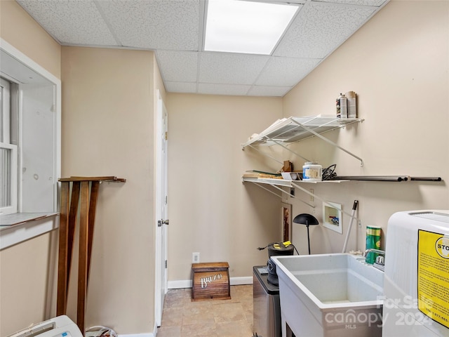 laundry room featuring washer hookup, light tile patterned floors, and sink