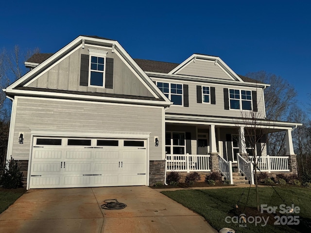 craftsman-style home with covered porch, a garage, and a front lawn