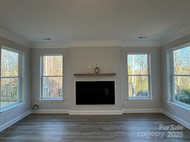 unfurnished living room featuring plenty of natural light and dark hardwood / wood-style flooring