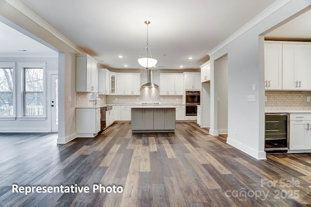 kitchen with dishwasher, white cabinets, double oven, and wall chimney exhaust hood