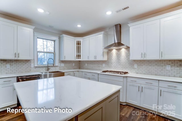 kitchen featuring white cabinetry, dark hardwood / wood-style floors, backsplash, wall chimney exhaust hood, and sink