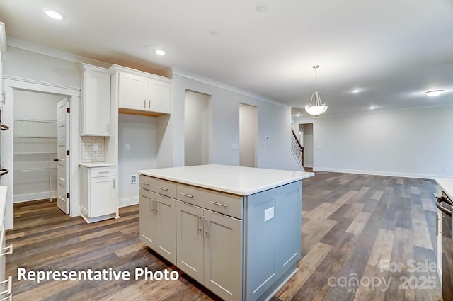 kitchen featuring pendant lighting, white cabinets, a kitchen island, dark wood-type flooring, and tasteful backsplash