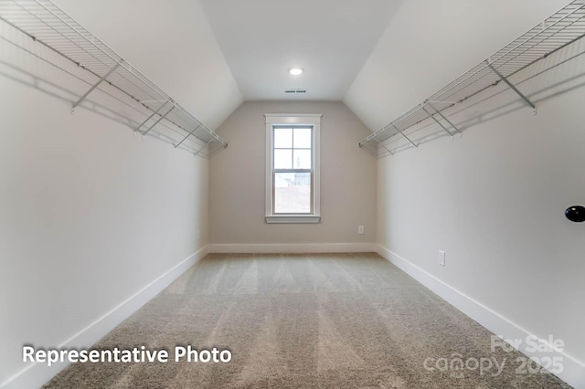 walk in closet featuring lofted ceiling and carpet flooring