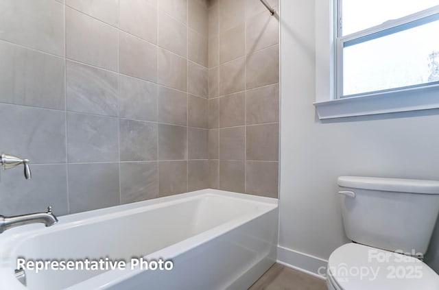 bathroom featuring shower / tub combination and toilet