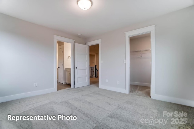 unfurnished bedroom with carpet floors, a closet, and a walk in closet