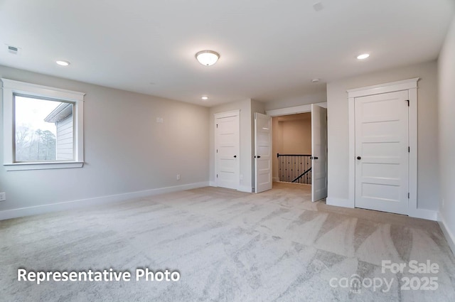 unfurnished bedroom featuring light carpet