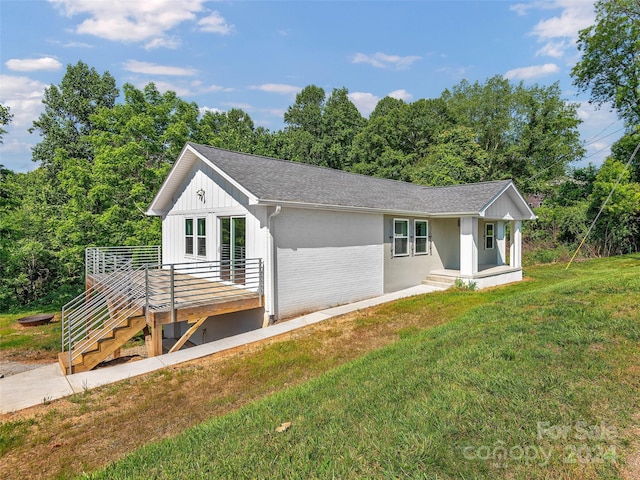 ranch-style house with a deck and a front yard