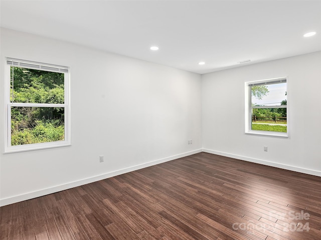 unfurnished room with dark hardwood / wood-style flooring