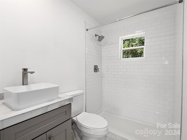 bathroom featuring vanity, toilet, and a tile shower