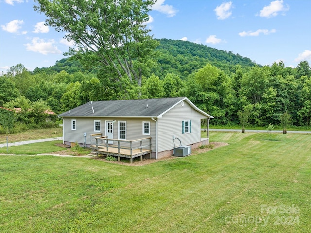 back of house featuring a lawn, central AC unit, and a wooden deck