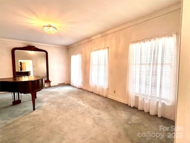 interior space featuring ornamental molding, plenty of natural light, and carpet flooring