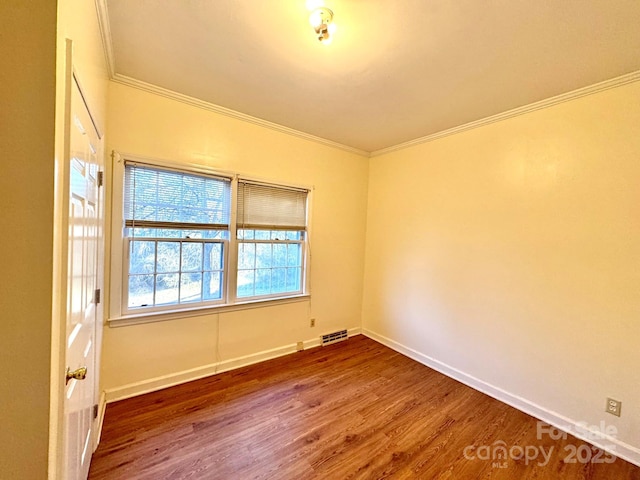 empty room featuring hardwood / wood-style flooring and crown molding