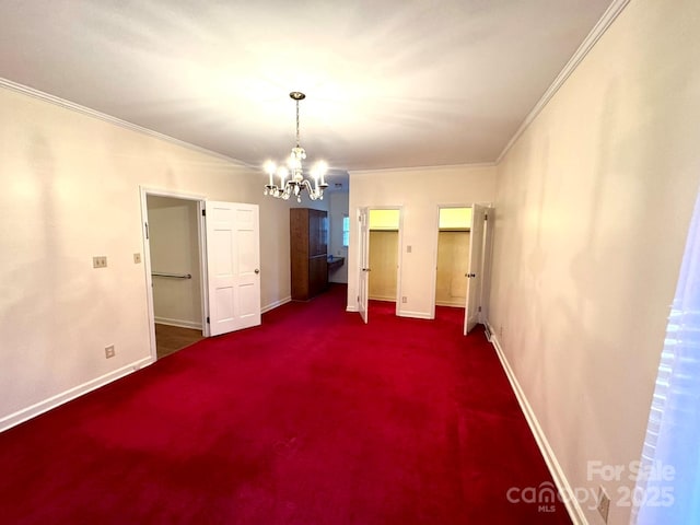 interior space featuring dark colored carpet, crown molding, and an inviting chandelier