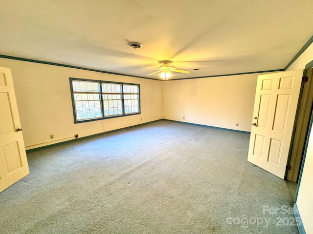 spare room with crown molding, ceiling fan, and carpet flooring