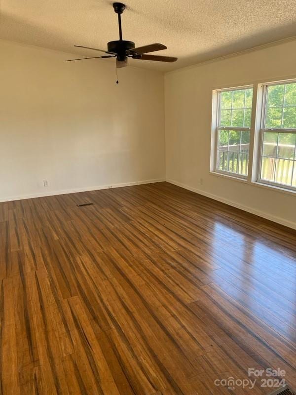 spare room with ceiling fan, dark wood-type flooring, and a textured ceiling