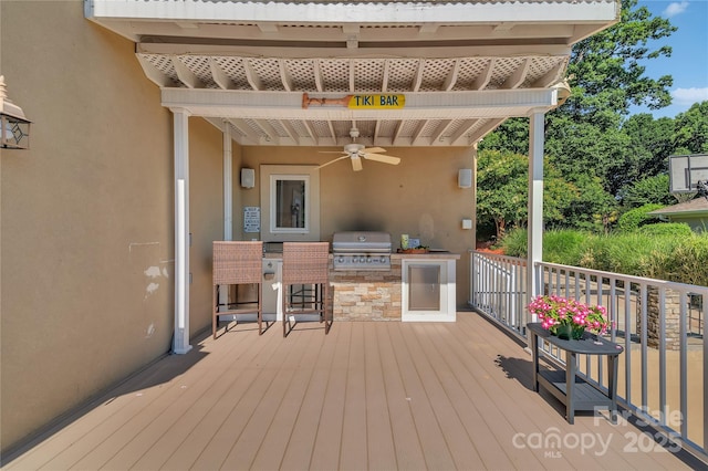 wooden terrace with ceiling fan, an outdoor kitchen, and grilling area