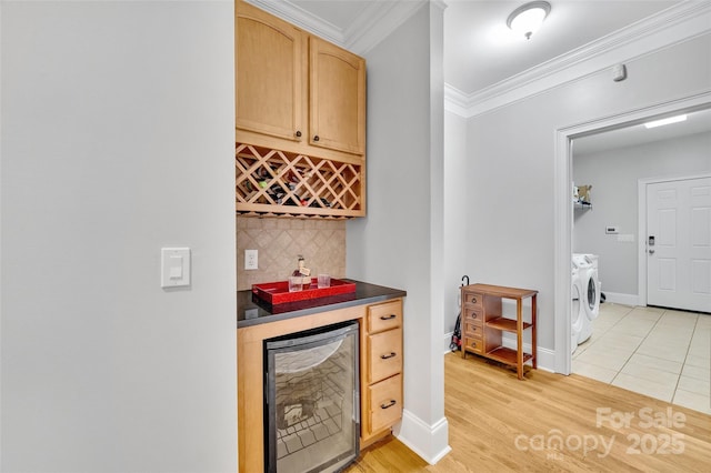 bar with tasteful backsplash, separate washer and dryer, wine cooler, light tile patterned floors, and crown molding