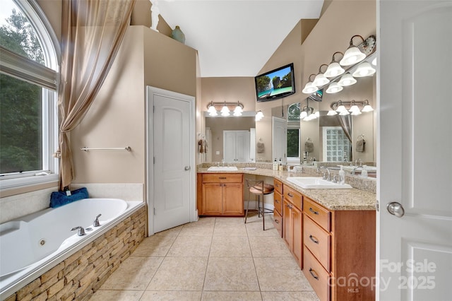 bathroom with lofted ceiling, vanity, tiled tub, a healthy amount of sunlight, and tile patterned floors