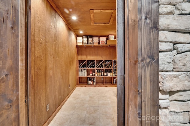 wine room featuring wood ceiling and wood walls