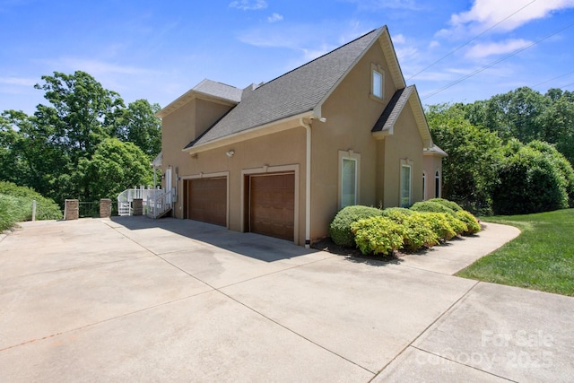 122 Long Cove Ln, Mooresville, NC 28117 - view of side of home with fence, stucco siding, a shingled roof, an attached garage, and driveway