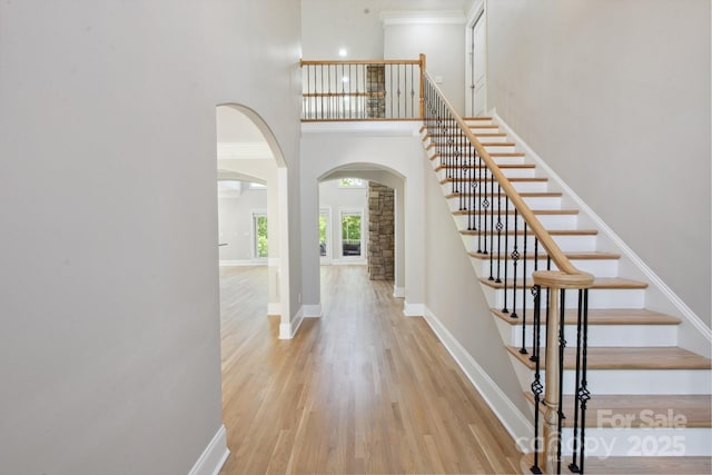 122 Long Cove Ln, Mooresville, NC 28117 - foyer entrance featuring arched walkways, light wood-style flooring, a high ceiling, and stairway