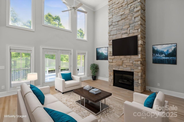 122 Long Cove Ln, Mooresville, NC 28117 - living area featuring baseboards, french doors, a stone fireplace, and wood finished floors