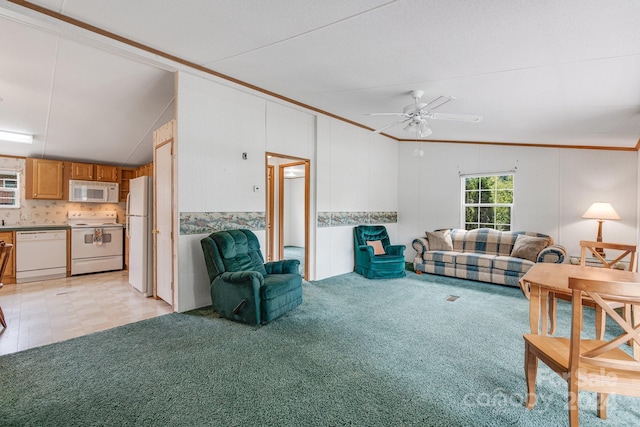 living room featuring lofted ceiling, ceiling fan, crown molding, and light colored carpet