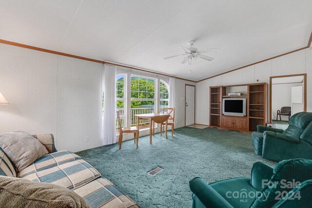 living room with ceiling fan, carpet, ornamental molding, and lofted ceiling