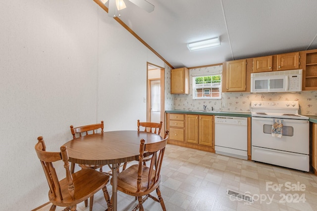 kitchen with vaulted ceiling, sink, and white appliances