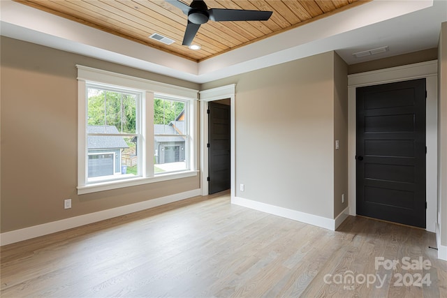 spare room featuring a raised ceiling, light hardwood / wood-style floors, ceiling fan, and wood ceiling