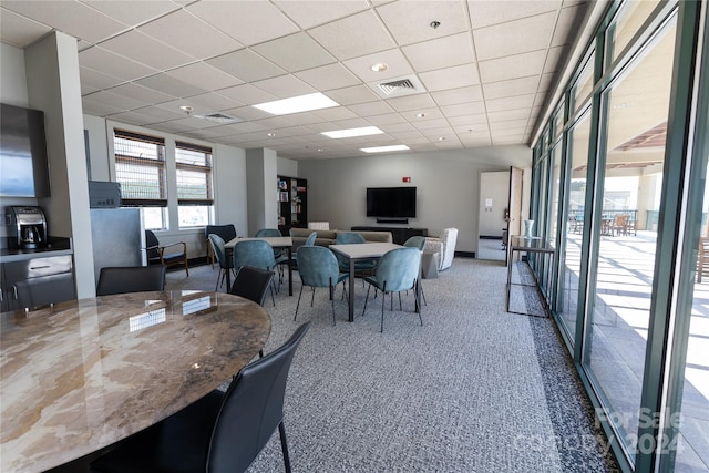 carpeted dining room with a paneled ceiling